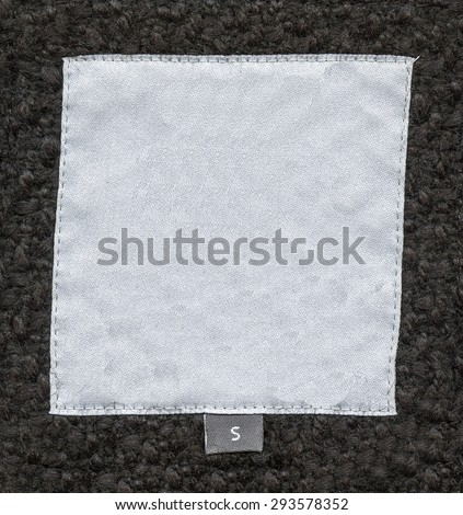 white textile tag on background of natural fur, size