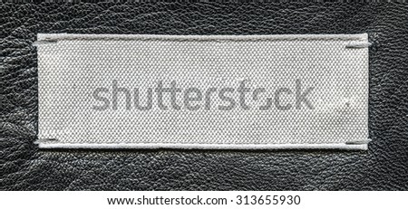 white textile tag  on leather background