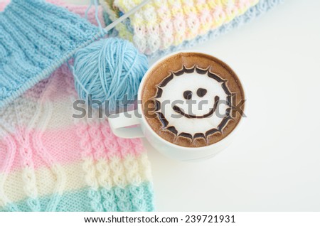 A cup of latte art and knitted vest