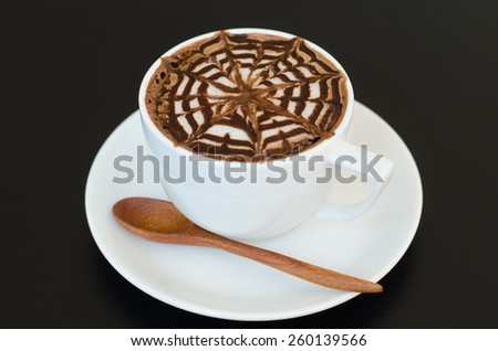 a cup of latte art on black background