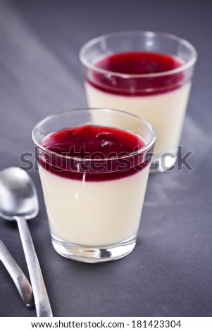 Close up of a glass of vanilla cream with a cherry jello topping