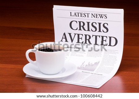 The newspaper LATEST NEWS with the headline CRISIS AVERTED on table
