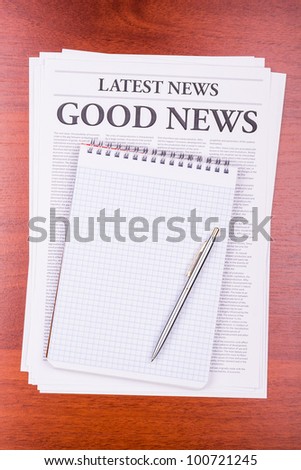 The newspaper LATEST NEWS with the headline GOOD NEWS and notepad