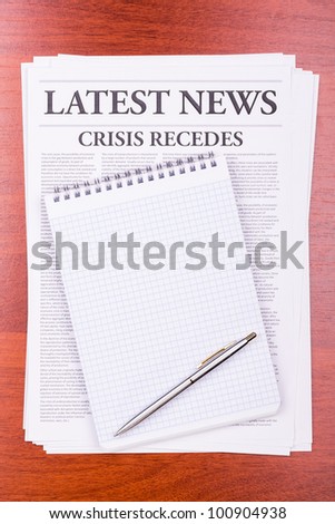 The newspaper LATEST NEWS with the headline CRISIS RECEDES and notepad