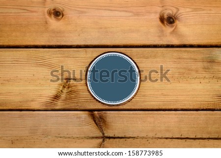 Wooden boards with a blue sticker label in the middle (write your text here)