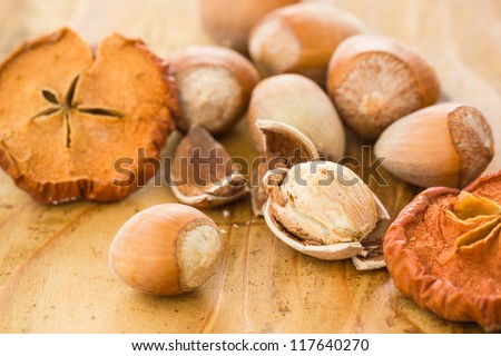 Dried Apples with Hazelnuts on a wooden Kitchen Table