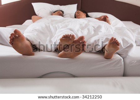 Bright Closeup of a young couple?s feet in bed