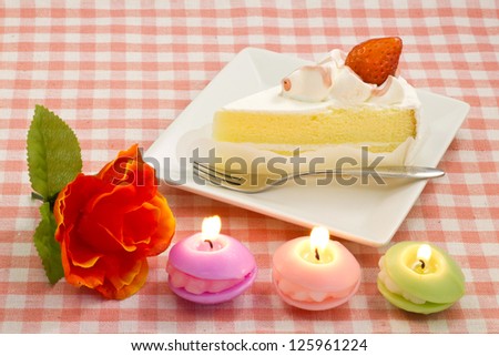candles and a rose and strawberry shortcake