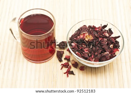 Tea made from rose hips in a glass dish and dried rose petals  stelyanoy in pan. Filmed in close-up on a bamboo napkin.