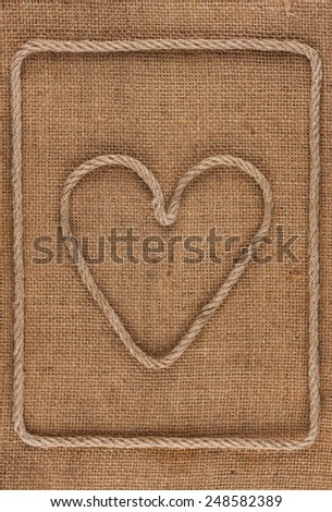 Heart made of rope on burlap, conceptual image