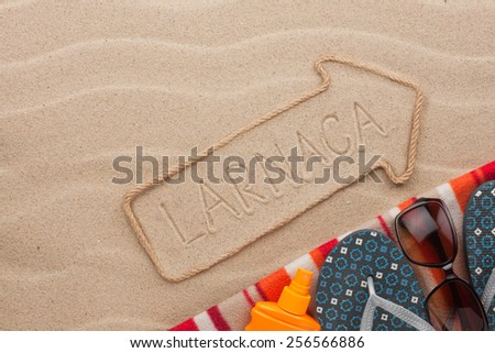Larnaca  pointer and beach accessories lying on the sand, as background