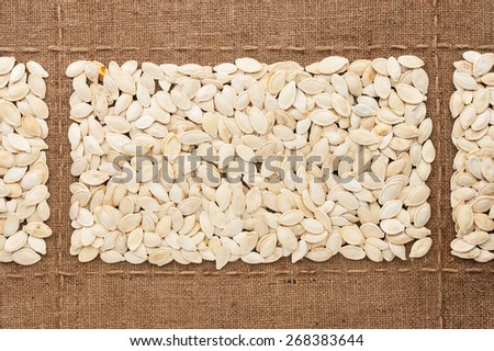Pumpkin seeds on sackcloth, with place for your text, drawing