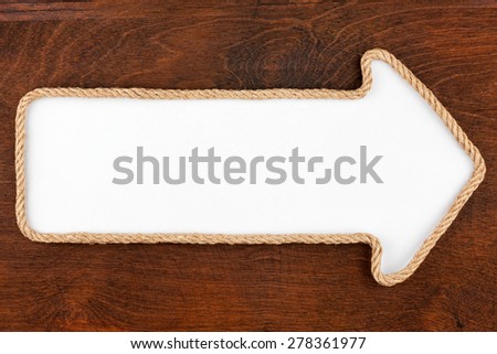Pointer made of rope with a white background on the wood, with place for your text