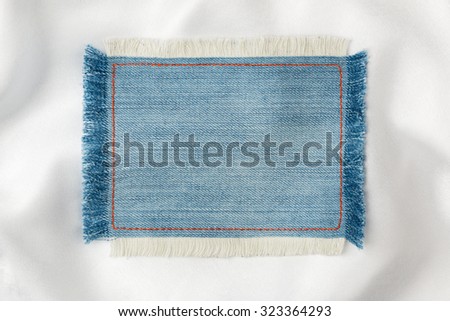 Frame made of denim fabric with yellow stitching on white silk, with space for your text