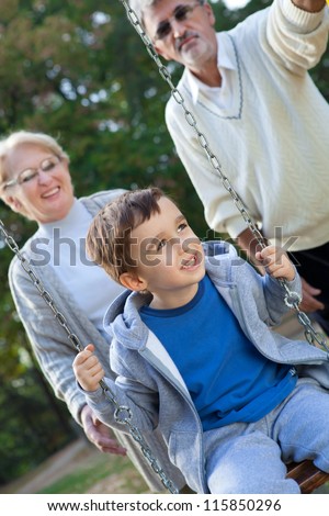 Grandma and Grandpa playing with grandson in the park, outdoors