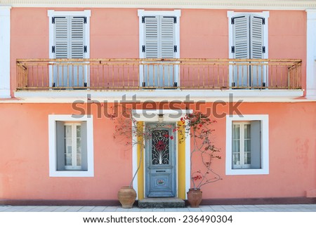Facade of a lovely greek house with flowers and balcony