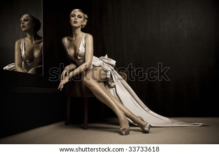 Sitting beautiful woman beside mirror