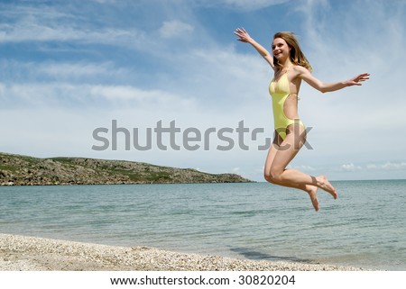 The girl in a bathing suit jumps on sea