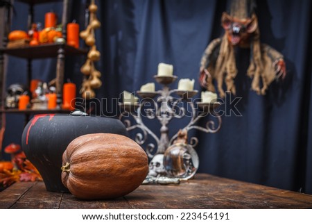 Table with a pot, pumpkin, crystal ball chandelier and to celebrate holiday halloween