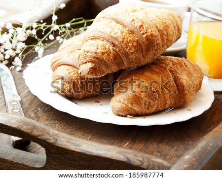 French Breakfast with Fresh Croissants, Flowers, Coffee and Orange Juice Glass