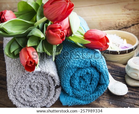 Spa Setting with Soft Cotton Towels and Red Tulips on Wooden Background