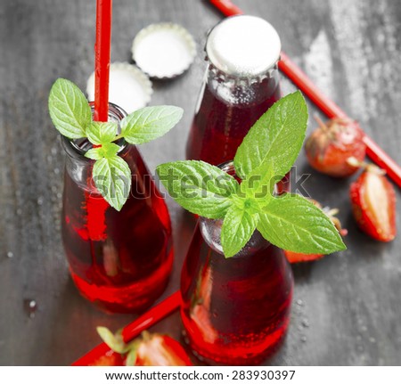 Refreshing Red Juice with Strawberries and Mint in Transparent Bottles with Straws