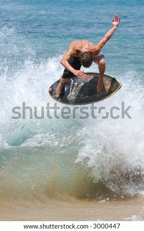 Young male surfer catching air off a wave