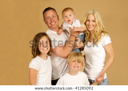 Portrait of a beautiful family of five all snuggled together in white tee shirts and jeans