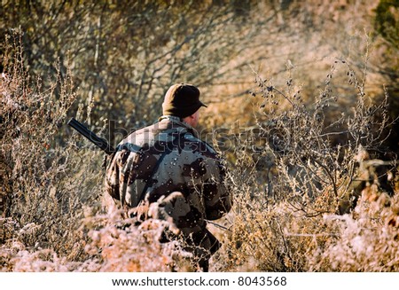 hunter stand and hold gun in the hand on the dry nature