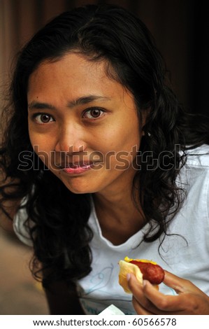 Asian Woman Eating a hot-dog or Sausage