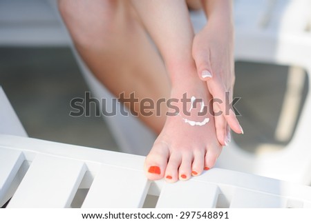 sun-protection cream on  leg on the beach