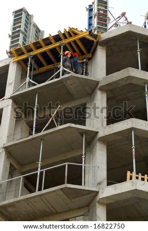 two workers looking on the roof  in the new building
