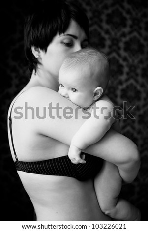 Mom shook hands on the cute baby who buried his mouth into her shoulder, a picture black and white