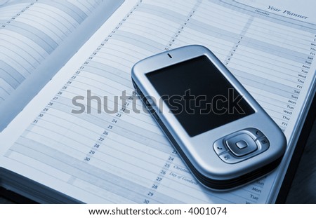A PDA and a diary showing (conceptually) how PDA\'s or Pocket PC\'s can be used for storing data.