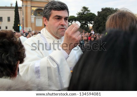 ROME, ITALY - April 07: A priest gives the communion to the crowd with hosts and blesses during the settlement ceremony of Pope Francis in Basilica of St. John Lateran on April 07, 2013 in Rome