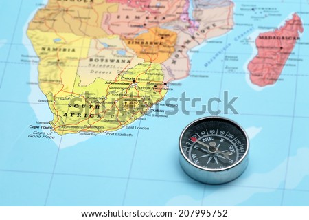 Compass on a map pointing at South Africa and planning a travel destination