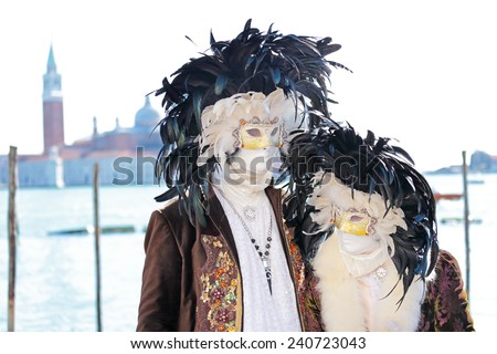 Couple of black and white masks decorated with feathers exhibited during the traditional Carnival of Venice, Italy (2014 edition)