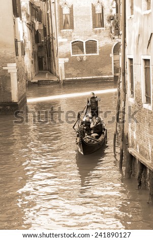 VENICE, ITALY - February 23: A gondolier carries a group of tourists through the canals of Venice with a gondola boat on February 23, 2014 in Venice, Italy. Photography in sepia tone