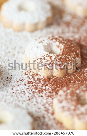 Closeup of italian canestrelli biscuits sprinkled with powdered sugar and cocoa. Vertical image