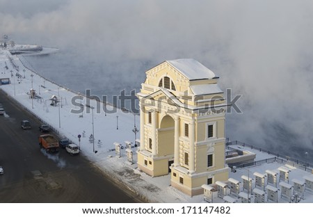Moscow gate on the background of hovering Angara-river in sunny winter day. Irkutsk