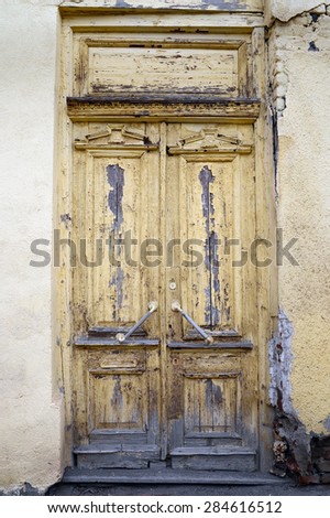 Old wooden door with peeling yellow paint