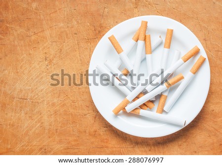 A pile of cigarettes on a plate top view. Stop smoking