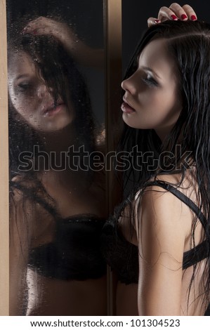 sexy and beautiful girl in black lingerie playing with herself through a dropped mirror with wet hair