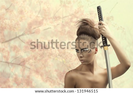 pretty brunette with japan make-up japan sword, she looks at right and takes the sword with left hand