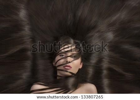 cute young girl laying with a lot of hair all around and some locks on face