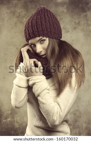 winter fashion shoot of a beauty young girl with long smooth hair, purple wool hat, scarf and warm white sweater