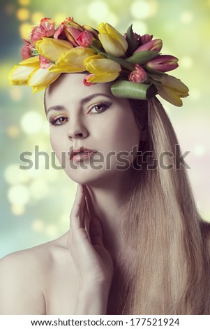 close-up spring portrait of sexy blonde girl, with long smooth hair, floral garland and colorful make-up. Looking in camera
