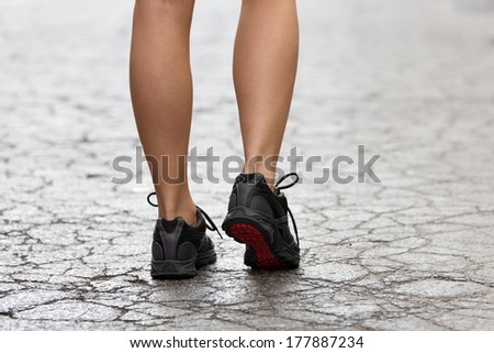 back shot of young lady with fitness shoes in act to walking ,running on a broken fashion road