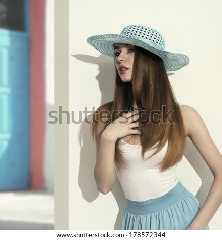 sensual young girl posing in fashion shoot with spring style, blue hat and skirt and silky long smooth hair