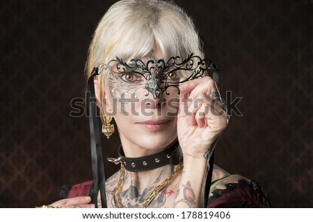 close-up portrait of tattoo woman with gothic costume and baroque mask